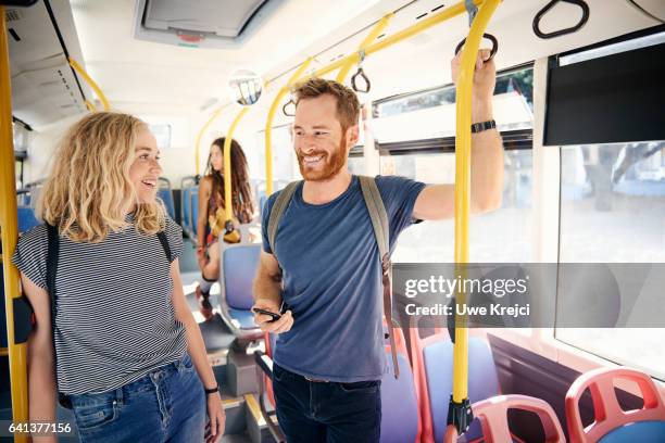 young smiling couple in a bus - man standing on bus stock pictures, royalty-free photos & images