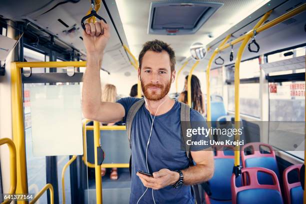 young man with headphones on a bus - public transport ストックフォトと画像