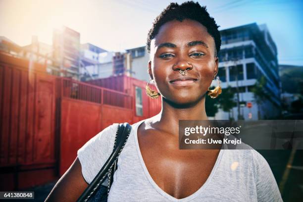 portrait of a young confident woman in the city - pendiente de la nariz fotografías e imágenes de stock