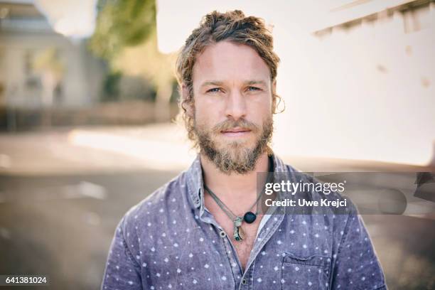 portrait of young bearded man in the city - handsome man serious tshirt stock-fotos und bilder