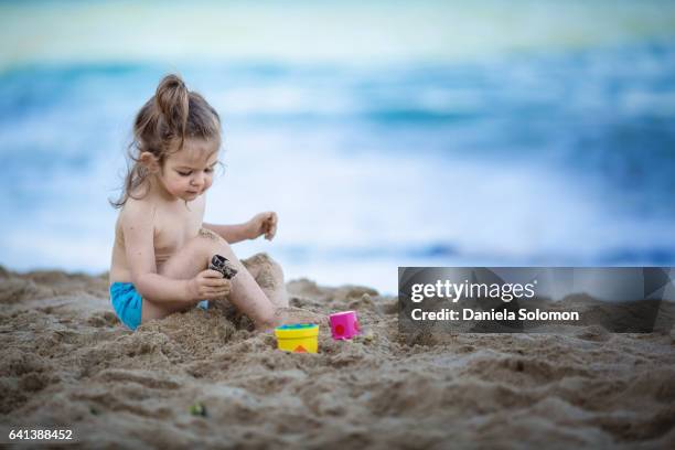 cute girl enjoying sand on the beach - 2 girls 1 sandbox stock pictures, royalty-free photos & images