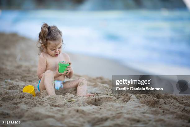 cute girl enjoying sand on the beach - 2 girls 1 sandbox stock pictures, royalty-free photos & images