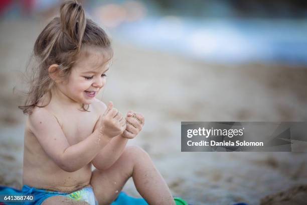 cute girl enjoying sand on the beach - 2 girls 1 sandbox stock pictures, royalty-free photos & images