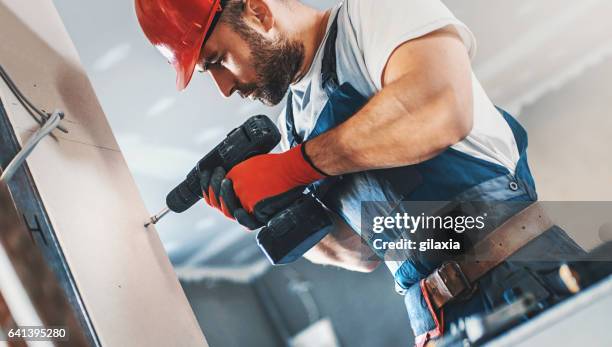 construction worker assembling a drywall. - electric screwdriver stock pictures, royalty-free photos & images