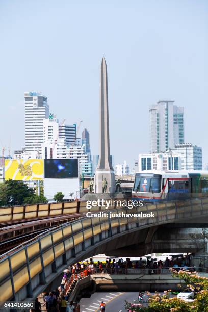 bts skytrain passing victory monument - verkehrswesen stock pictures, royalty-free photos & images