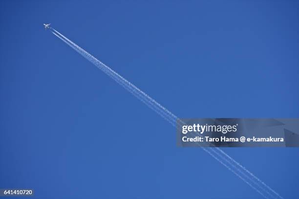 airplane vapor trail in blue sky - rastro de avião - fotografias e filmes do acervo