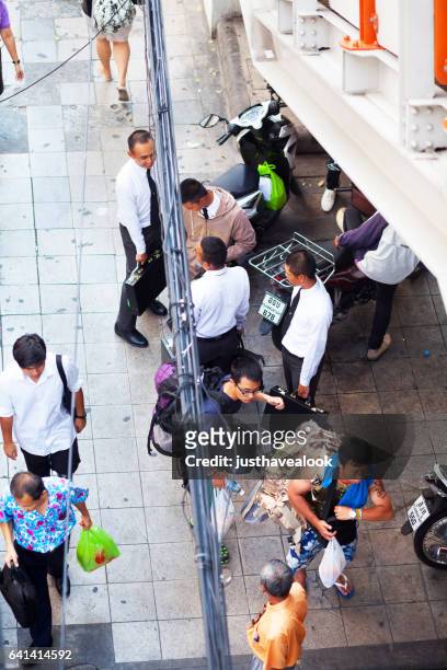 thai men and students on sidewalk - junge männer stock pictures, royalty-free photos & images