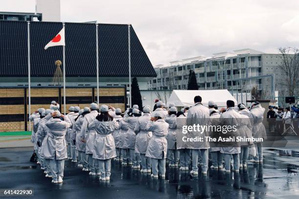 Team Japan members watch the national flag is hoisted during the welcome ceremony at the Athletes Village ahead of the Nagano Winter Olympic Games on...