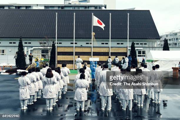 Team Japan members watch the national flag is hoisted during the welcome ceremony at the Athletes Village ahead of the Nagano Winter Olympic Games on...