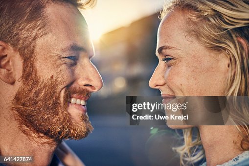 Young couple smiling at each other, close up Young couple smiling at each other, close up