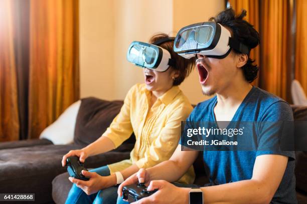 young couple playing virtual reality games together - friendly match stock pictures, royalty-free photos & images