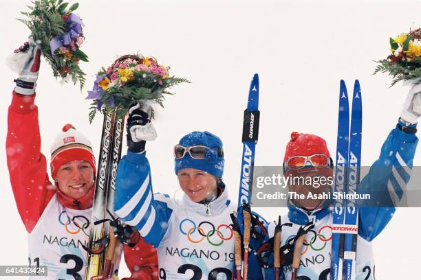 Bronze medalist Anita Moen-Guidon of Norway, gold medalist Olga Danilova of Russia and Silver medalist Larisa Lazutina of Russia celebrate on the...