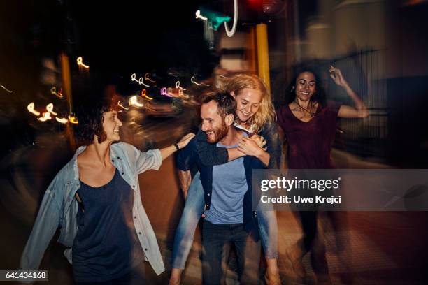 group of young people in the city at night - piggyback stock pictures, royalty-free photos & images