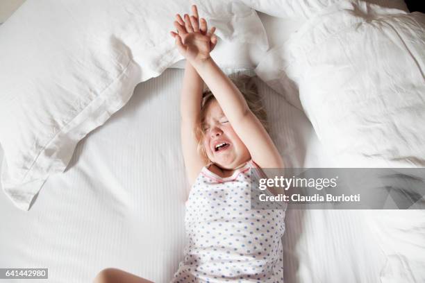 little girl crying in bed - trotzanfall stock-fotos und bilder