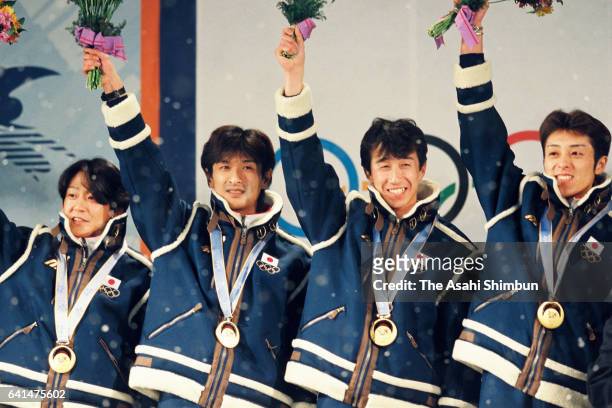 Gold medalists Takanobu Okabe, Hiroya Saito, Masahiko Harada and Kazuyoshi Funaki of Japan celebrate on the podium at the medal ceremony for the Ski...