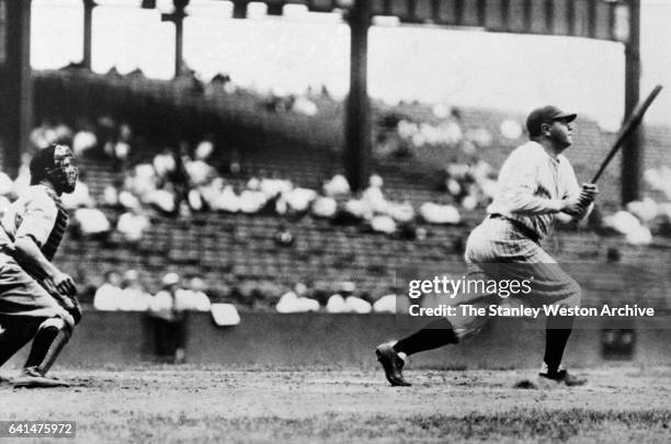 Babe Ruth watches his home run fly over the outfield wall in Dunn Field, Cleveland, Ohio, August 20, 1927. Luke Sewell is the Indians catcher.