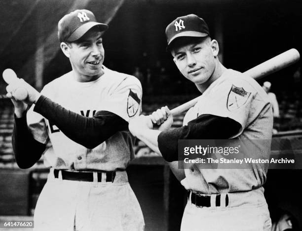 New York Yankees sluggers Joe DiMaggio and Mickey Mantle posing for the camera with their pine bats, 1951.