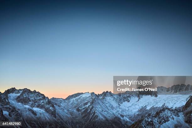 sunrise behind mountain range - twilights fotografías e imágenes de stock