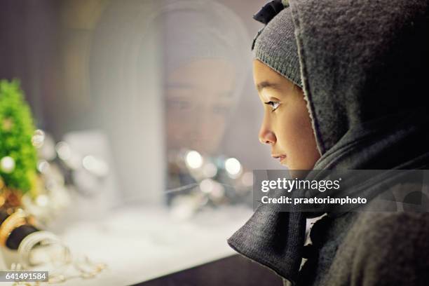 poor girl is looking sad a jewelry store window - homeless winter stock pictures, royalty-free photos & images