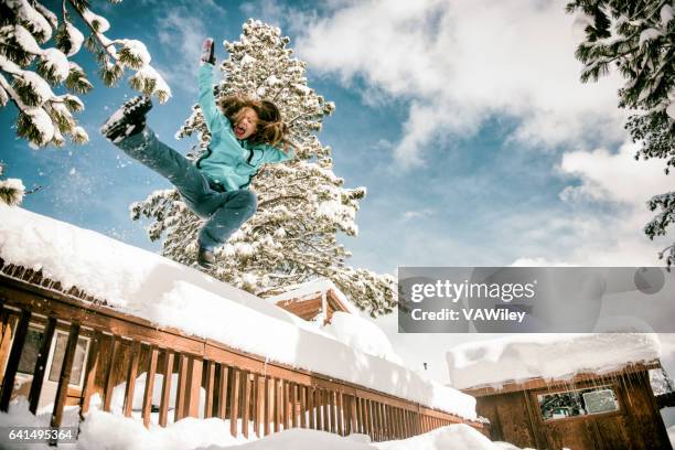 girl jumping dramatically off porch into snow - kicks off imagens e fotografias de stock