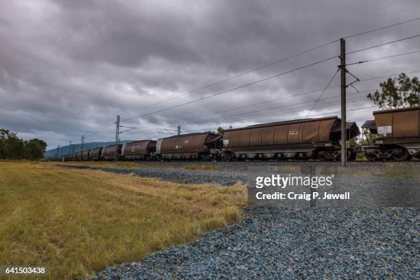 passing coal train under overcast skies - queensland rail stock pictures, royalty-free photos & images