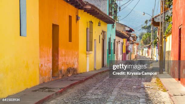 colorful street in old colonial city of antigua, guatemala - antigua guatemala stock-fotos und bilder