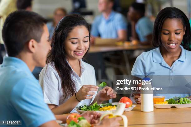private high school students eat a healthy lunch in cafeteria - fruit and vegetables salad stock pictures, royalty-free photos & images