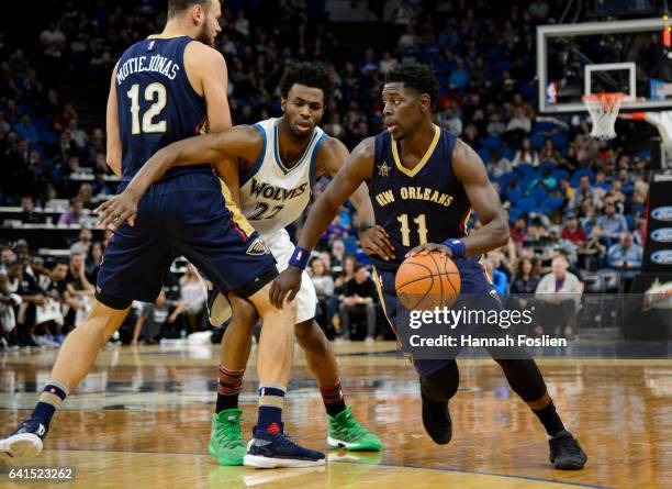Donatas Motiejunas of the New Orleans Pelicans sets a pick for Andrew Wiggins of the Minnesota Timberwolves as teammate Jrue Holiday drives to the...