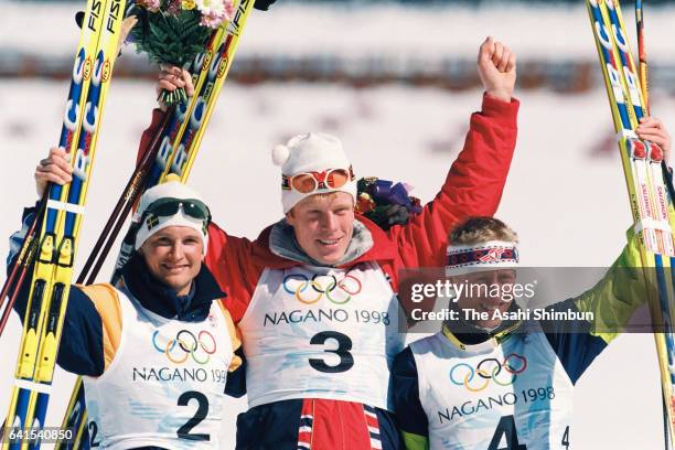 Silver medalist Niklas Jonsson of Sweden, gold medalist Bjorn Daehlie of Norway and bronze medalist Christian Hoffmann of Austria celebrate on the...