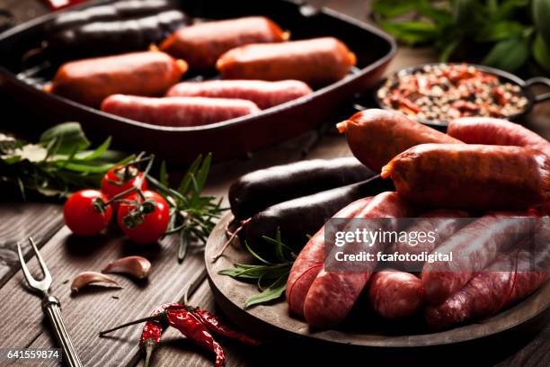 sausages variation on dark wood table - raw sausages stock pictures, royalty-free photos & images