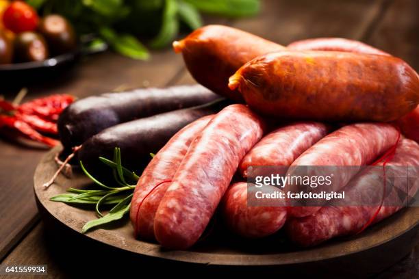 sausages variation on dark wood table - sausage stock pictures, royalty-free photos & images