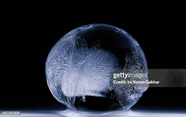 close up photograph of spherical ice sculpture - ice sculpture stock-fotos und bilder