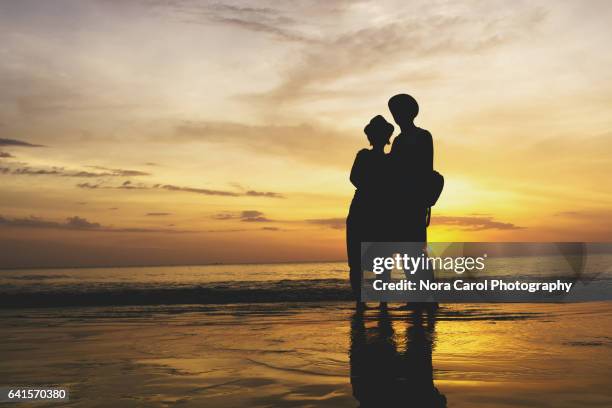 silhouette of a couple during sunset - kota kinabalu beach stock pictures, royalty-free photos & images