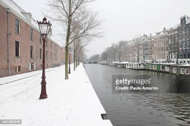 beautiful view in the street snow and canal in amsterdam - snow coverd stock pictures, royalty-free photos & images