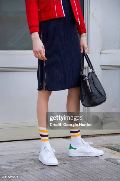 Guest is seen at Spring Studios outside the Lacoste show wearing red sports jacket with white detail, blue ribbed knit tight three quarter length...