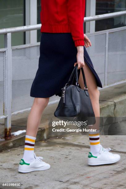 Guest is seen at Spring Studios outside the Lacoste show wearing red sports jacket with white detail, blue ribbed knit tight three quarter length...