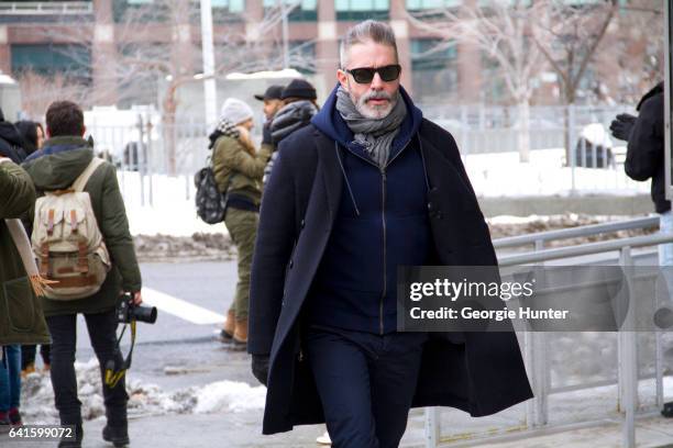 Garth Condit is seen at Spring Studios outside the Lacoste show wearing blue pants, zip up hoodie and coat on February 11, 2017 in New York City.