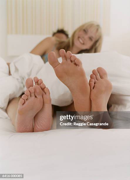 couple in bed - feet in bed stock-fotos und bilder