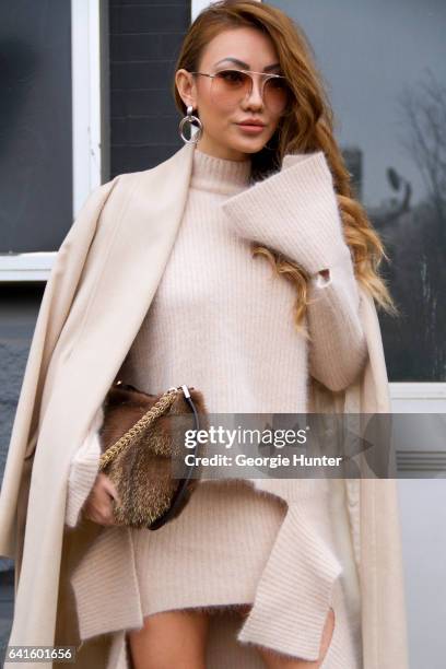 Jessica Wang is seen at Spring Studios outside the Lacoste show wearing draped nude wool knit outfit of skirt, sweater and coat with flared sleeves,...