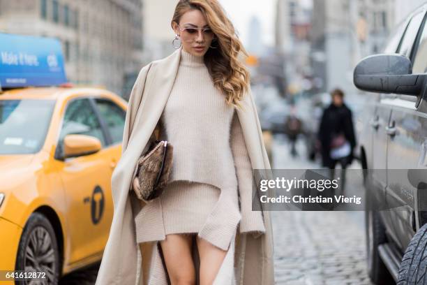 Guest wearing a beige knit, skirt, wool coat, ankle boots outside Lacoste on February 11, 2017 in New York City.