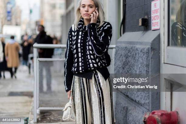 Guest wearing a black knit, striped pants outside Lacoste on February 11, 2017 in New York City.