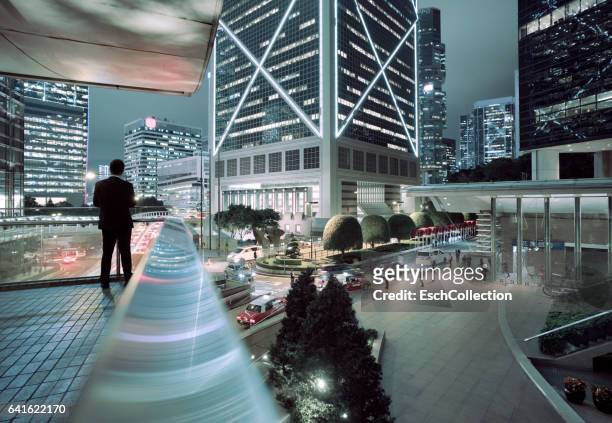 businessman looking at illuminated central district of hong kong - china modern city stockfoto's en -beelden