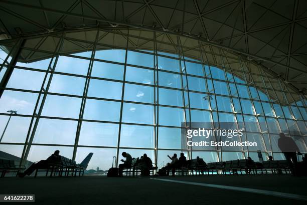 people waiting at gate of modern airport - hong kong international airport stock pictures, royalty-free photos & images