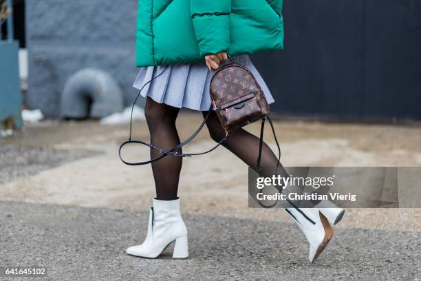 Guest wearing a Louis Vuitton backpack, white ankle boots outside Lacoste on February 11, 2017 in New York City.
