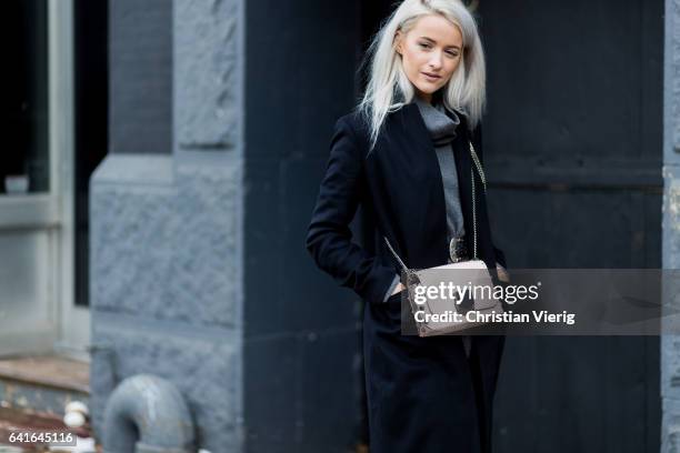 Guest wearing a black coat, knit, Dior bag outside Lacoste on February 11, 2017 in New York City.