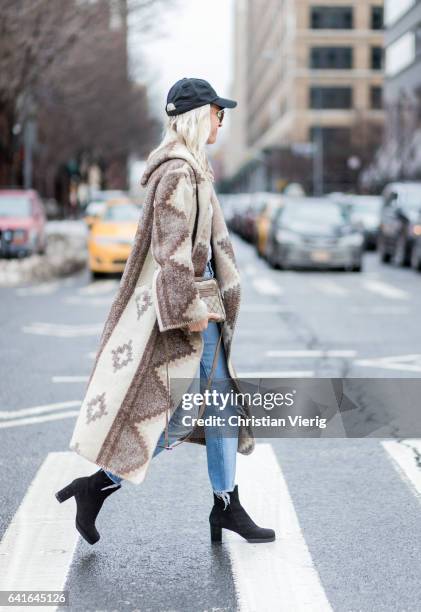 Guest wearing a coat, flex cap, ankle boots outside Creatures of the Wind on February 11, 2017 in New York City.