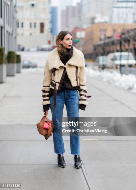 Irina Lakicevic wearing a turtleneck knit, beige sheepskin jacket, Loewe bag, denim outside Creatures of the Wind on February 11, 2017 in New York...