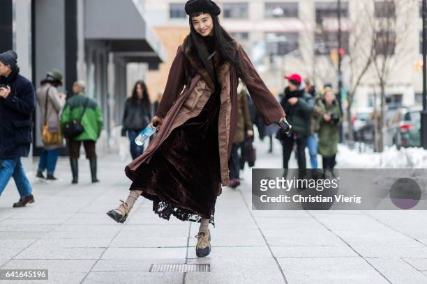 Model wearing a brown coat, brown velvet pants, beret outside Creatures of the Wind on February 11, 2017 in New York City.