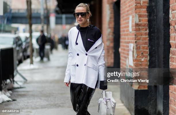 Celine Aargaard wearing a Vetements hoody, white jacket, Loewe bag, vinyl pants outside Tibi on February 11, 2017 in New York City.