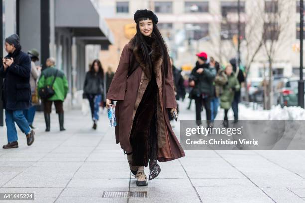 Model wearing a brown coat, brown velvet pants, beret outside Creatures of the Wind on February 11, 2017 in New York City.